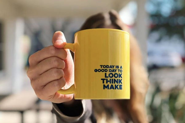 a yellow coffee mug with "today is a good day to lookthinkmake" on it