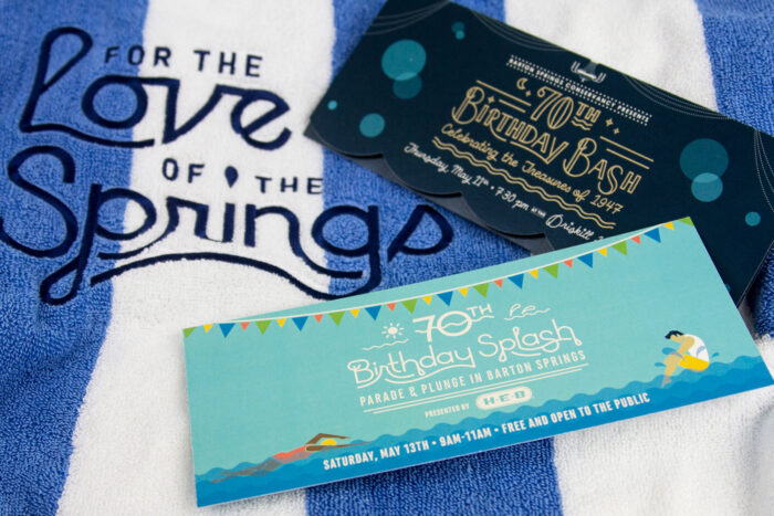 A blue and white beach towel with "For the love of the springs" embroidered on it with a party invitation on top